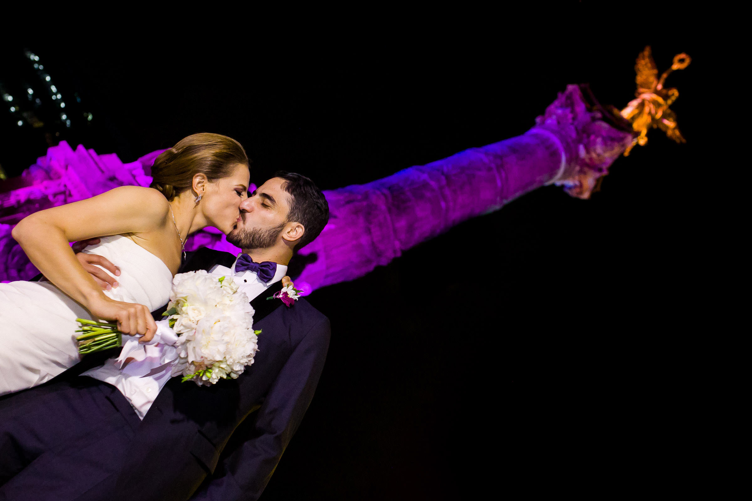 Novios judios besandose frente al ángel de la independencia el día de su boda.