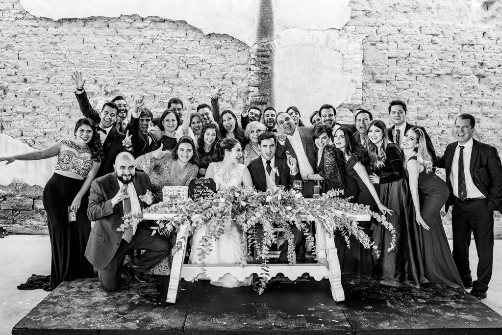 Invitados felices posando en la foto familiar de la boda