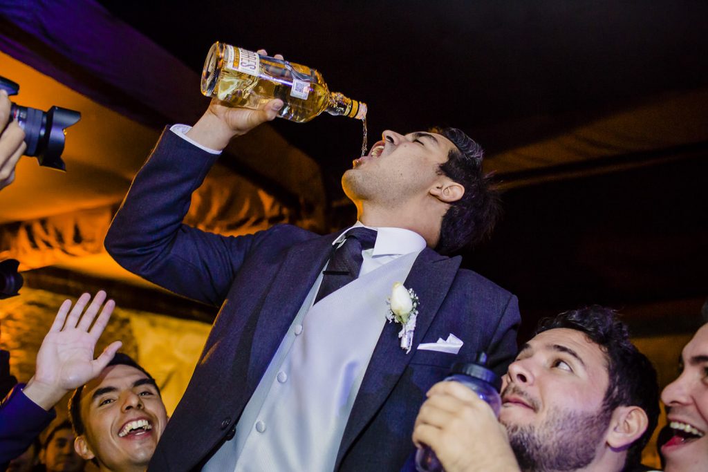 El novio festejando con sus amigos y un trago de tequila